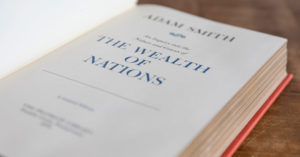 The Wealth of Nations by Adam Smith cover photographed. The cover was a profile of Adam Smith and the title The Wealth of Nations.